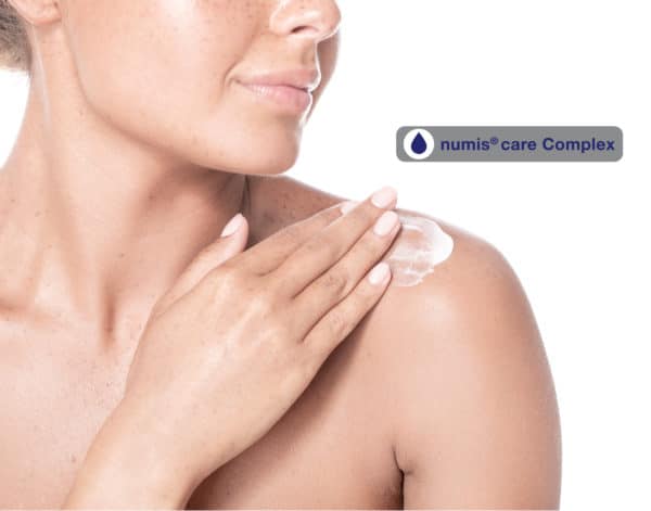 Frau, die sich die Schulter eincremt mit numis® care Complex